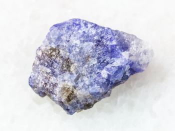 macro shooting of natural mineral rock specimen - rough crystal of Tanzanite stone on white marble background from Tanzania