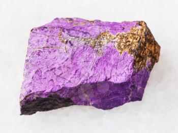 macro shooting of natural mineral rock specimen - Purpurite stone on white marble background from Karibib district, Namibia