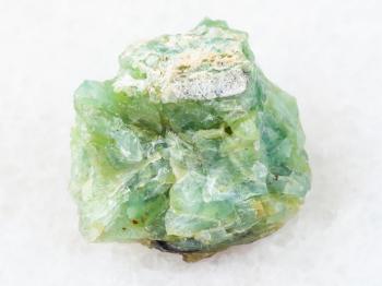macro shooting of natural mineral rock specimen - crystal of chrysopal gemstone on white marble background from Pstan mine, Kazakhstan