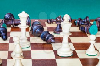 business concept - falling black side (except pawn) and wining white side of chess