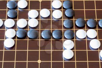 top view of gameplay of Go game on wooden board