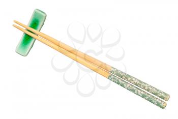 top view of decorated wooden chopsticks served on chopstick rest isolated on white background