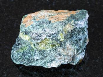macro shooting of natural mineral - rough beryl rock on black granite from Ural Mountains