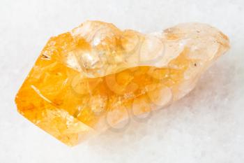 macro shooting of natural rock specimen - crystal of Citrine (yellow quartz) gemstone on white marble background from Brazil