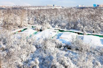 aerial view of snow-covered garages between urban Timiryazevsky park and apple orchard in Koptevo district of Moscow city in sunny winter day