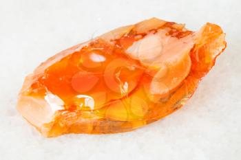 macro shooting of natural mineral - rough noble opal and fire opal gem stone on white marble from Ural Mountains