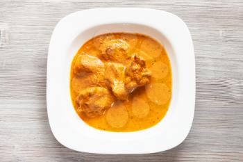 Indian cuisine - Murg Makhan Masala barbequed chicken pieces in spicy tomato and creamy curry sauce in white bowl