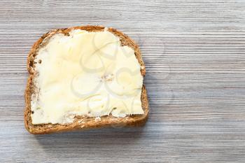 top view of bread sandwich with buttered butter on gray wooden board with blank copyspace