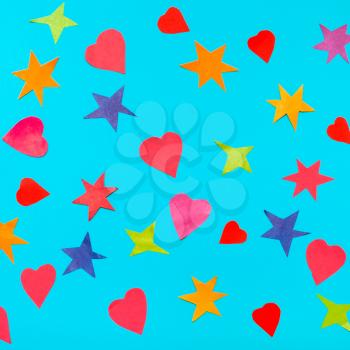 collage of multicolored stars and hearts cut from papers on blue turquoise pastel paper