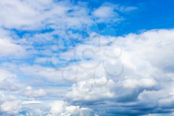 natural background - dense white clouds in blue sky on summer day