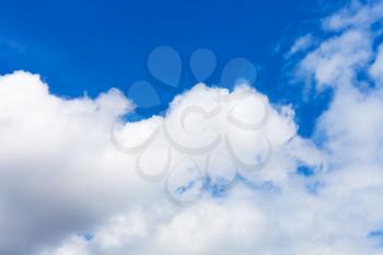 natural background - bottom view of large cumulus white and gray cloud in blue sky on summer day