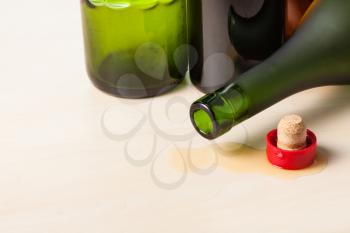 few empty wine bottles and cork on wooden board