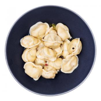 top view of buttered Pelmeni (russian dumplings filled with minced meat) in black bowl isolated on white background