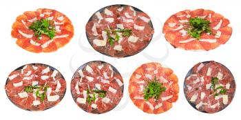 collection of served served Carpaccio (thinly sliced raw beef fillet) dishes on plate isolated on white background