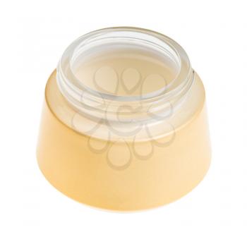 open empty yellow shiny glass jar for cosmetic cream isolated on white background