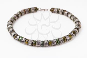 antique arabic necklace from faceted Jadeite gems and silver rings on white paper background