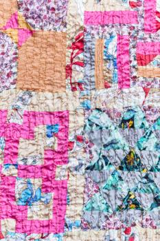 textile background - textured patchwork scarf stitched from various silk strips and crushed pink cotton fabric