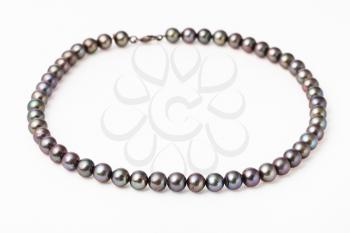 necklace from natural black pearls on white paper background