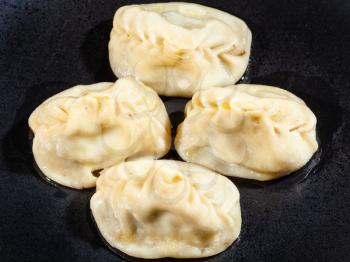 few of boiled Manti (type of dumpling in turkic cuisine) on black plate