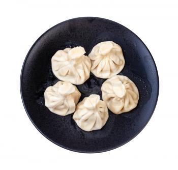 georgian cuisine - top view of five boiled khinkali on black plate isolated on white background
