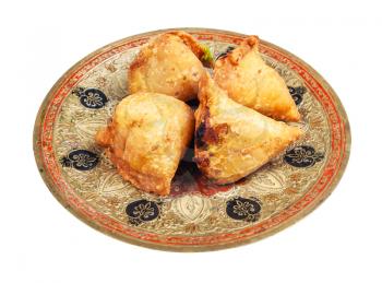 Indian cuisine - portion of keema samosas (fried savoury pastry filled by meat and vegetables) on brass plate isolated on white background