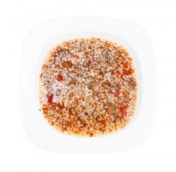 top view of meat soup with buckwheat in white soup plate isolated on white background