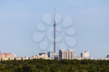 residential district with TV tower and lush green forest on horizon on sunny September day in Moscow city