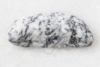 closeup of sample of natural mineral from geological collection - rolled Magnesite rock on white marble background from Satkinskoe deposit, Southern Urals, Russia