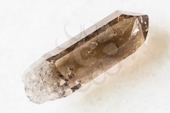 closeup of sample of natural mineral from geological collection - rough crystal of Smoky Quartz on white marble background from Pelinguichy, Inta, Komi, Russia
