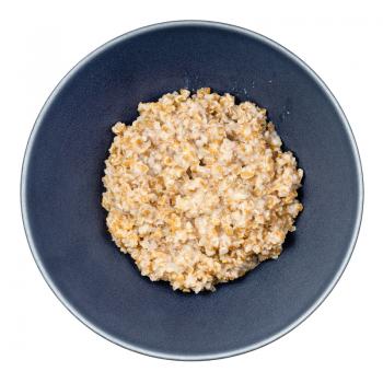 top view of porridge from boiled crushed Emmer farro hulled wheat groats in round bowl isolated on white background