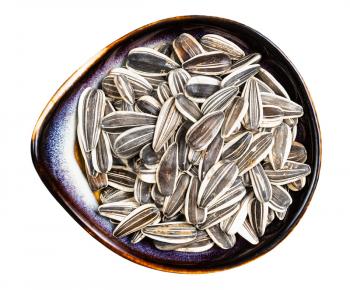 top view of whole sunflower seeds in ceramic bowl isolated on white background