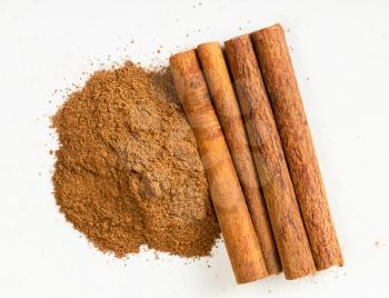 top view of cinnamon sticks and powder close up on gray ceramic plate
