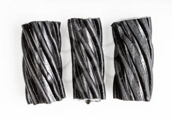 few coiled black licorice candies on white plate