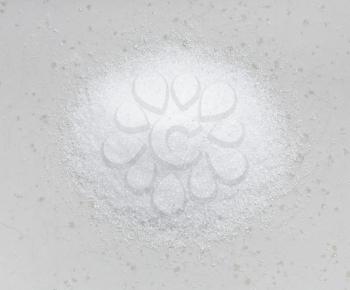 top view of pile of crystalline erythritol sugar substitute close up on gray ceramic plate