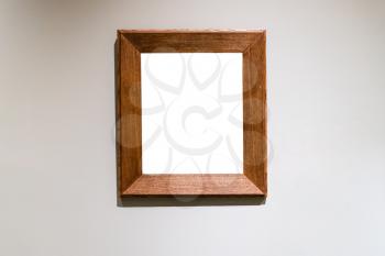 flat wide vertical wooden picture frame with cutout canvas on gray wall