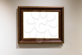 wide dark brown wooden picture frame with cutout canvas on gray wall