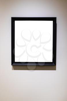 square black picture frame with cutout canvas on gray vertical wall