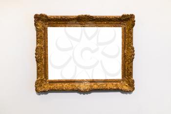 old decorated wide gold picture frame with cutout canvas on gray wall
