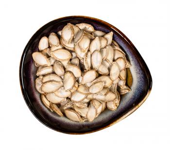 top view of whole pumpkin seeds in ceramic bowl isolated on white background