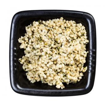 top view of cores of hemp seeds in black bowl isolated on white background
