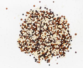 top view of pile of blend of quinoa grains close up on gray ceramic plate