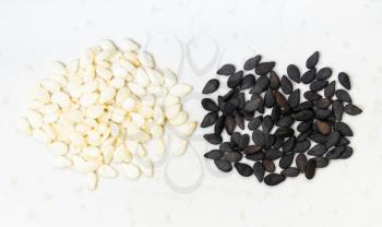 top view of black and white sesame seeds close up on gray ceramic plate