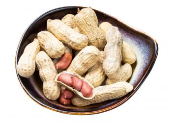 peeled and whole peanuts in ceramic bowl isolated on white background