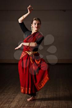 Young woman in sary dancing classical traditional indian dance Bharat Natyam