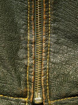 Zipper on a black leather taken closeup as background.