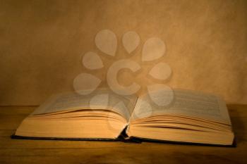 Old magic book on a wooden table in a darkness.