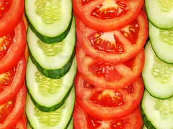 Slices of tomatoes and cucumbers arranged in a row suitable as background.