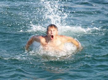 Man swims in the sea waves.