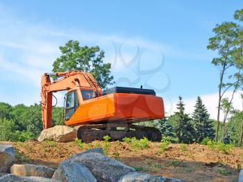 Orange dredge on a  forests hillside.