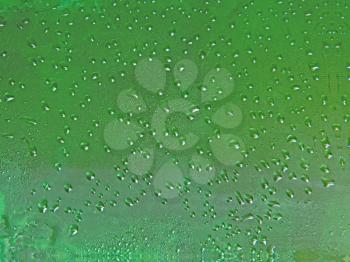 Drips on green beer bottle taken closeup suitable as background.